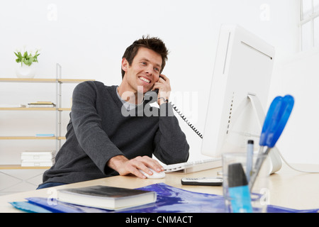 Imprenditore parlando al telefono in ufficio Foto Stock