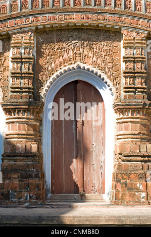 Carving ornati di miti indù al di sopra di una porta, Baranagar, rurale Bengala Occidentale, India, Asia Foto Stock