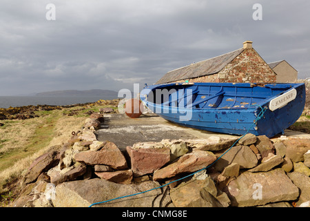 Una barca in bretella accanto al percorso costiero dell'Ayrshire a Portencross sul Firth of Clyde nel Nord Ayrshire, Scozia, Regno Unito Foto Stock