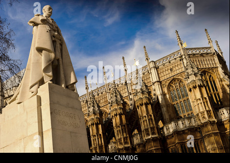 Statua di re Giorgio V con Westminster Abbey in background Foto Stock
