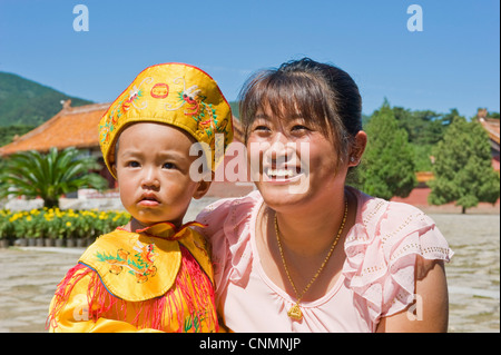 Una giovane madre cinese e il suo bambino vestito in abiti tradizionali mentre visitano le Tombe Qing Orientali. Foto Stock