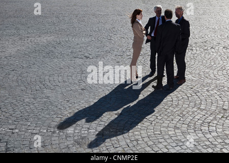 La gente di affari di parlare sul lastricato della strada Foto Stock