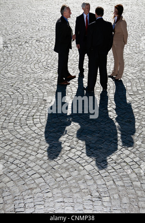 La gente di affari di parlare sul lastricato della strada Foto Stock