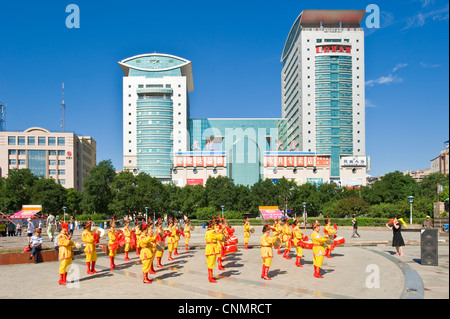 La piazza della città di Chengde con un gruppo di donne locali riproduzione di musica tradizionale e di indossare abiti tradizionali. Foto Stock