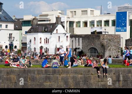 La folla godendo il sole all'Arco Spagnolo quays nella città di Galway, Irlanda Foto Stock