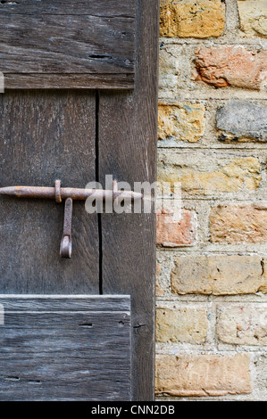 In prossimità di una finestra in legno otturatore e un muro di mattoni Foto Stock