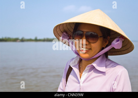 Chiudere orizzontale su ritratto di un attraente il vietnamita donna che indossa un tradizionale nón lá cappello di paglia. Foto Stock