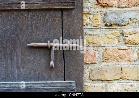 In prossimità di una finestra in legno otturatore e un muro di mattoni Foto Stock