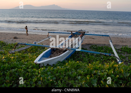 Un tradizionale outrigger barche da pesca sulla spiaggia di Dili Timor orientale con l'isola di Atauro all'orizzonte Foto Stock