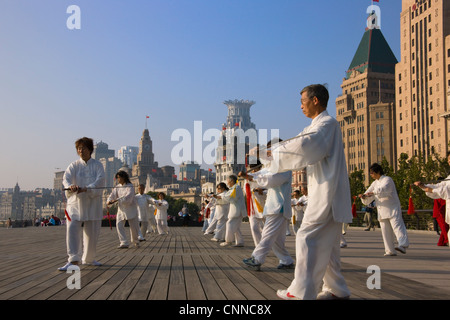 Persone che praticano il Taiji con la spada sul Bund al mattino, Shanghai, Cina Foto Stock