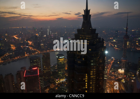 Vista notturna della skyline lungo le rive del fiume Huangpu dominato dal palazzo Jinmao, Shanghai, Cina Foto Stock