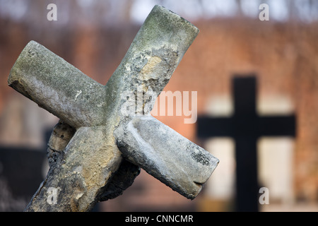 Un vecchio ottocento lastra tombale pendente croce al cimitero, sfondo sfocato, la profondità di campo di una composizione Foto Stock