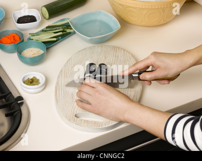 Donna sushi chopping a tavola Foto Stock