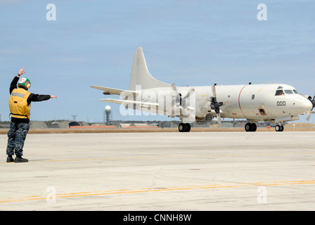 Aviation Electrician's Mate 3a Classe Ian Stinton, attaccato a Patrol Squadron (VP) 1, guida un aereo P-3 mentre si tassano attraverso la rampa Naval Air Facility Misawa, 20 aprile 2012. VP-1 è attualmente in fase di implementazione nel Giappone settentrionale a supporto della settima operazione Fleet Operations. Foto Stock