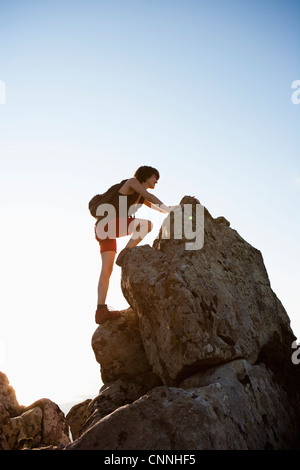 Escursionista rocce arrampicata sulla collina Foto Stock