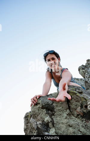 Escursionista offrendo aiuto rock climbing Foto Stock