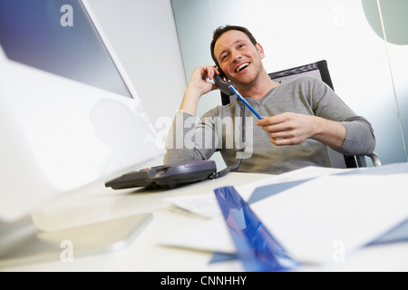 Imprenditore parlando al telefono in ufficio Foto Stock