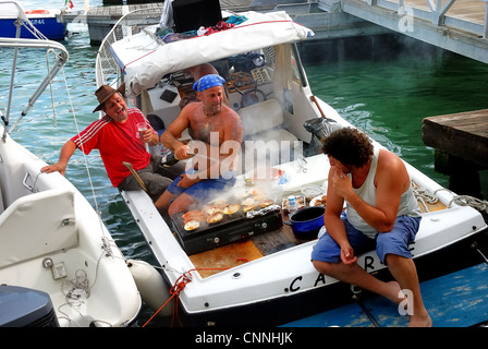 Venezia, Luglio 16th, 2011. La festa del Redentore. Tre veneziani la cottura del pesce in barca. Foto Stock