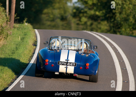 Vista posteriore di un AC Cobra auto sportiva essendo guidato su una strada in inglese. Foto Stock