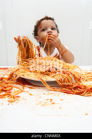 Ragazzo di mangiare gli spaghetti con le mani Foto Stock