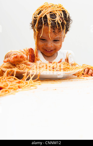 Ragazzo di mangiare gli spaghetti con le mani Foto Stock