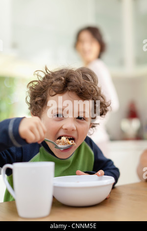 Ragazzo di consumare la colazione in cucina Foto Stock