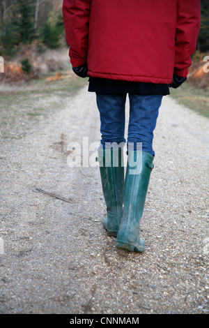 Backview della Donna che cammina sul percorso di paese, Farnham, Inghilterra Foto Stock