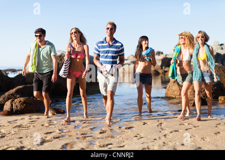 Amici di sorridere camminando sulla spiaggia Foto Stock