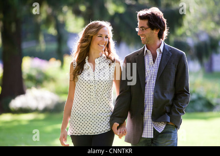 Coppia giovane a piedi attraverso il parco Foto Stock