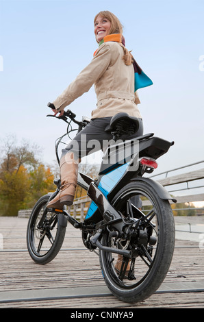 Equitazione donna bike sulla passerella in legno Foto Stock