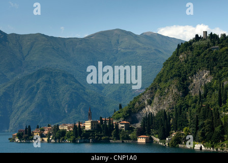 Il comune di Varenna si accoccola accanto al lago di Como, vegliato dal Castello de Vezio, Italia. Foto Stock