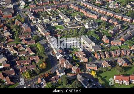 Vista aerea di convenienti nuove case costruite su un campo marrone sito tra le case più vecchie Foto Stock