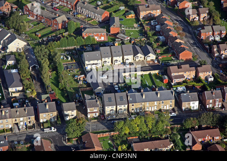 Vista aerea di convenienti nuove case costruite su un campo marrone sito tra le case più vecchie Foto Stock
