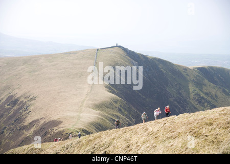 Walkers sul crinale Nantlle con l'Obelisco dietro in Snowdonia nel Galles del Nord Foto Stock