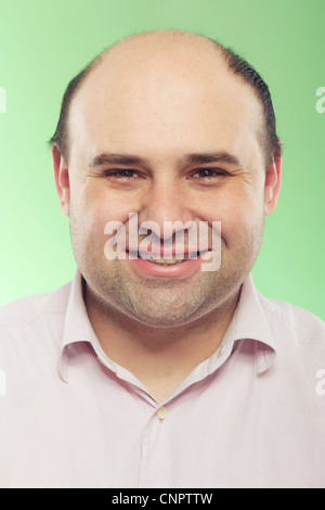 Ritratto di un vero uomo sorridente in studio su uno sfondo verde Foto Stock