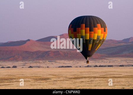 Mongolfiera all'alba volando a bassa quota sopra il gigante dune di sabbia a Sossusvlei, Namibia del sud Africa Foto Stock