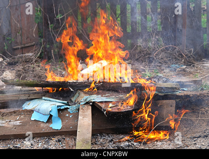 Vigili del fuoco di fiamma bruciare rifiuti tossici veleno illegale nuvole Foto Stock