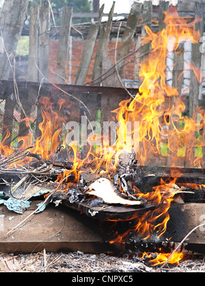 Tossico vigili del fuoco di fiamma illegale bruciare rifiuti in città di fumo di veleno Foto Stock