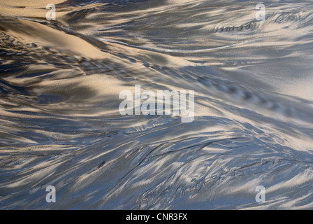 Spiaggia di sabbia con un piccolo trafilamento di acqua fluente Foto Stock