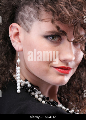 Ragazza - ear piercing super donna capelli scuri marrone naturale dai capelli sfondo nero Foto Stock