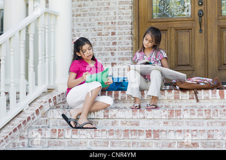 Le ragazze facendo i compiti sul passi Foto Stock