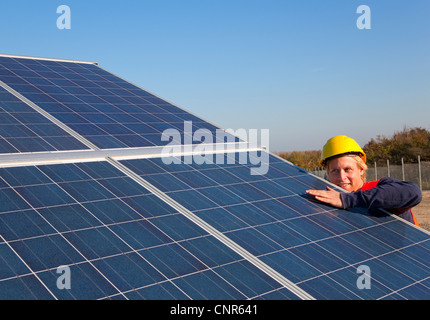 Lavoratore esaminando i pannelli solari Foto Stock