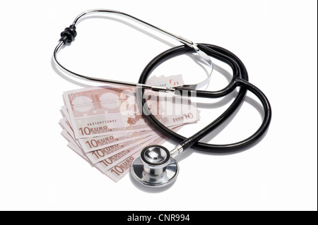 Un medici lo stetoscopio e le banconote in euro Foto Stock