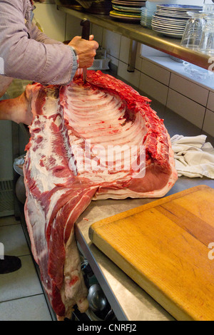 Butcher il taglio di carne di maiale Foto Stock