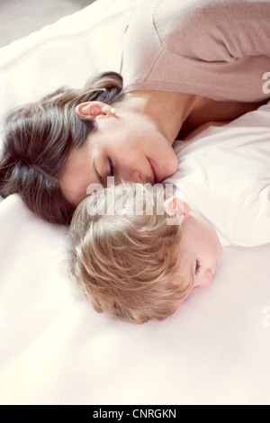 Madre sonnecchiare con il giovane figlio Foto Stock