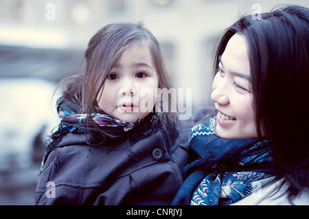 Madre e figlia giovane all'aperto, ragazza guardando la fotocamera Foto Stock
