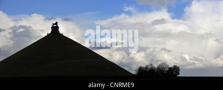 Lion Hill stagliano contro il cielo nuvoloso, monumento in memoria del 1815 Battaglia di Waterloo, Eigenbrakel vicino a Bruxelles, in Belgio Foto Stock