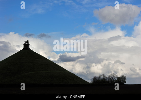 Lion Hill stagliano contro il cielo nuvoloso, monumento in memoria del 1815 Battaglia di Waterloo, Eigenbrakel vicino a Bruxelles, in Belgio Foto Stock