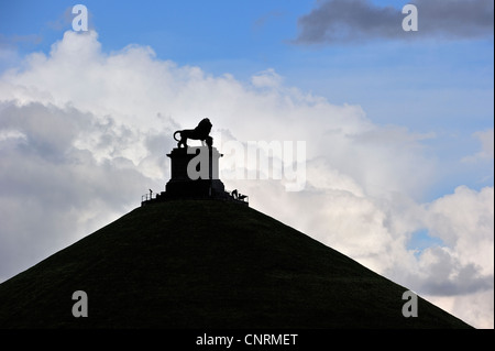 Lion Hill stagliano contro il cielo nuvoloso, monumento in memoria del 1815 Battaglia di Waterloo, Eigenbrakel vicino a Bruxelles, in Belgio Foto Stock