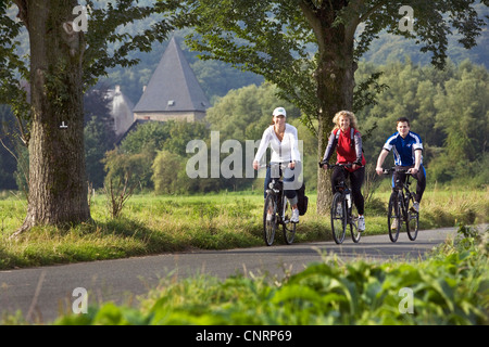 Tre persone in bicicletta sulla Valle della Ruhr Cycleway, Kemnade castle in background, in Germania, in Renania settentrionale-Vestfalia, la zona della Ruhr, Witten Foto Stock